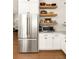 Chef's kitchen featuring stainless steel refrigerator, white cabinetry, and open shelving at 240 Mado Ln, Chattahoochee Hills, GA 30268