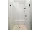 Modern shower featuring glass doors, matte black hardware and white herringbone tile at 240 Mado Ln, Chattahoochee Hills, GA 30268