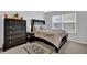 Bedroom features a black bed frame, wooden dresser, and light-filled window at 3000 Storybook Ln, Grayson, GA 30017