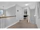 Hallway with wood railing and neutral carpet leads to bedrooms and stairs at 3000 Storybook Ln, Grayson, GA 30017