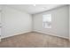Cozy bedroom with a window allowing natural light to fill the space and neutral carpeting at 345 Orwell Dr, Social Circle, GA 30025