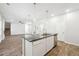 Open concept kitchen with island, stainless dishwasher, and views into the living and dining area at 345 Orwell Dr, Social Circle, GA 30025