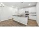 Bright kitchen features white cabinets, stainless appliances, and a large island with pendant lighting at 345 Orwell Dr, Social Circle, GA 30025
