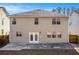Back exterior of a home featuring a small patio, neutral siding, and multiple windows for natural light at 4319 Alysheba Dr, Fairburn, GA 30213