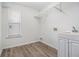 Functional laundry room with a utility sink, shelving, and updated flooring at 4319 Alysheba Dr, Fairburn, GA 30213