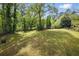 Large backyard with lush green grass and mature trees providing privacy and space for outdoor activities at 627 Warsaw Rd, Roswell, GA 30075