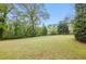 Spacious backyard with mature trees and green grass, perfect for relaxation and outdoor activities at 627 Warsaw Rd, Roswell, GA 30075