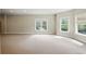 Large, carpeted basement with large windows offering plenty of natural light at 627 Warsaw Rd, Roswell, GA 30075
