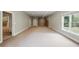 A carpeted basement with a large window and adjacent utility area at 627 Warsaw Rd, Roswell, GA 30075