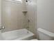 Tiled shower-tub combo with white porcelain fixtures and neutral colored tiling at 627 Warsaw Rd, Roswell, GA 30075