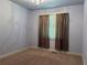 Light-filled bedroom with carpet flooring, simple window with curtains, and neutral colored walls at 627 Warsaw Rd, Roswell, GA 30075