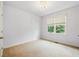Bright bedroom with neutral carpet, a modern light fixture and a sunlit window at 627 Warsaw Rd, Roswell, GA 30075