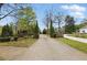 Long driveway leading to a beautiful home with mature landscaping and a charming wooden fence at 627 Warsaw Rd, Roswell, GA 30075