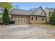 Charming home exterior featuring a stone-accented garage and a spacious driveway at 627 Warsaw Rd, Roswell, GA 30075