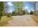 Spacious driveway leading to a beautiful home with mature trees and well-maintained landscaping at 627 Warsaw Rd, Roswell, GA 30075