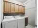 Functional laundry room with upper cabinets, utility sink, washer, and dryer at 627 Warsaw Rd, Roswell, GA 30075