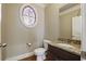Elegant powder room with granite countertop vanity, oval window, and decorative finishes at 627 Warsaw Rd, Roswell, GA 30075