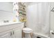 White bathroom with a shower/tub combo, toilet, sink and vanity, and wood heart-shaped shelves at 640 Maple Dr, Riverdale, GA 30274