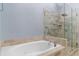 Bright bathroom features a whirlpool tub and a frameless glass shower with tiled walls and shower niche at 818 Highland Green Ne Way # 818, Atlanta, GA 30306