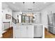 Bright kitchen features a center island with stainless steel dishwasher and sink, adjacent to stairs leading to upper level at 818 Highland Green Ne Way # 818, Atlanta, GA 30306
