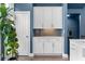 White cabinets with display counter and neutral backsplash complement a light blue wall and natural light from adjacent door at 818 Highland Green Ne Way # 818, Atlanta, GA 30306