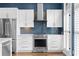 Modern kitchen boasts stainless steel appliances, white cabinets, and a stylish backsplash, complemented by natural light from the window at 818 Highland Green Ne Way # 818, Atlanta, GA 30306