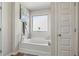 Bright bathroom with a soaking tub, large window, and neutral decor at 15 Mary Jane Ln, Covington, GA 30016