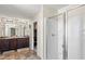 Well-lit bathroom with double vanities, a glass-enclosed shower, and tile floors at 15 Mary Jane Ln, Covington, GA 30016
