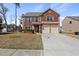 Charming two-story brick home features a two-car garage and well-maintained front lawn at 15 Mary Jane Ln, Covington, GA 30016
