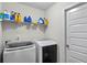 Functional laundry room featuring modern washer and dryer units and storage shelves at 15 Mary Jane Ln, Covington, GA 30016