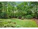 Beautiful backyard featuring lush greenery, mature trees, and a well-manicured lawn at 370 Fairleaf Ct, Alpharetta, GA 30022