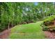 Well-maintained backyard with lush green lawn, landscaping, and privacy trees at 370 Fairleaf Ct, Alpharetta, GA 30022