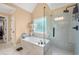Luxurious bathroom with a soaking tub, a walk-in glass shower, and natural light at 370 Fairleaf Ct, Alpharetta, GA 30022