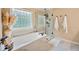 Bright bathroom features a soaking tub, glass shower, and decorative window at 370 Fairleaf Ct, Alpharetta, GA 30022