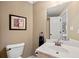 Well-lit bathroom with a single sink vanity and a framed mirror above the toilet at 370 Fairleaf Ct, Alpharetta, GA 30022