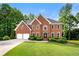 Stately brick home with two-car garage, manicured lawn, and mature trees at 370 Fairleaf Ct, Alpharetta, GA 30022