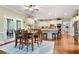 Spacious kitchen with white cabinets, stainless appliances, island seating, and an adjacent dining area at 370 Fairleaf Ct, Alpharetta, GA 30022