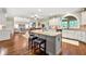 Open kitchen featuring granite countertops, an island with seating, and hardwood floors leading to the living room at 370 Fairleaf Ct, Alpharetta, GA 30022