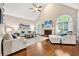Open living room with vaulted ceilings, a fireplace, large arched windows, and hardwood floors at 370 Fairleaf Ct, Alpharetta, GA 30022