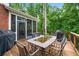 Outdoor wooden patio with dining furniture, grill, and screened in porch at 370 Fairleaf Ct, Alpharetta, GA 30022