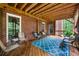 Covered outdoor porch features wooden ceiling, blue rug, and brick wall at 370 Fairleaf Ct, Alpharetta, GA 30022