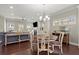 Open dining area with hardwood floors, chandelier lighting, and view of the living room at 3724 Via Secco Ln, Suwanee, GA 30024