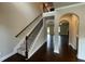 Spacious entryway featuring hardwood floors, a carpeted staircase, and arched doorways at 3818 Southfield Ct, Loganville, GA 30052