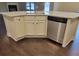 Close-up of a kitchen island with a sink, stainless steel dishwasher, and white cabinets at 3818 Southfield Ct, Loganville, GA 30052