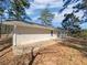 Backyard with a concrete patio and a grassy hill leading to a treeline at 5520 Morning Creek Cir, Atlanta, GA 30349