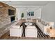 Bright living room with a brick fireplace, ceiling fan, neutral paint, and large windows, virtually staged at 5520 Morning Creek Cir, Atlanta, GA 30349