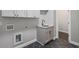 Convenient laundry room with modern gray cabinetry and sleek black herringbone floors at 837 Lakemont Dr, Canton, GA 30114