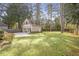 Spacious backyard featuring a detached two car garage and a partially fenced yard surrounded by mature trees at 3207 Kensington Rd, Avondale Estates, GA 30002