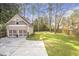 View of detached two-car garage with a large backyard featuring mature trees and a privacy fence at 3207 Kensington Rd, Avondale Estates, GA 30002