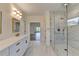 Bright, open bathroom featuring a glass shower, double vanity, and marble accents at 5533 Addison Woods Pl, Buford, GA 30518